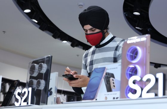 インドのある電子製品の売り場で男性顧客がサムスン電子の「Ｇａｌａｘｙ　Ｓ２１」を見ている。［写真　サムスン電子］