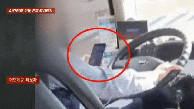 スマホで株価をチェックする高速バス運転手