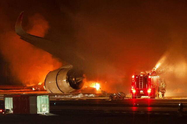 羽田空港のC滑走路で炎上する日航516便の消火作業